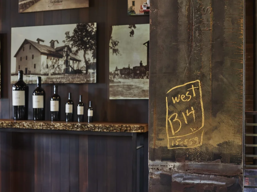 A tasting bar with bottles lined up, historic photographs on the wall and a chalked block number.